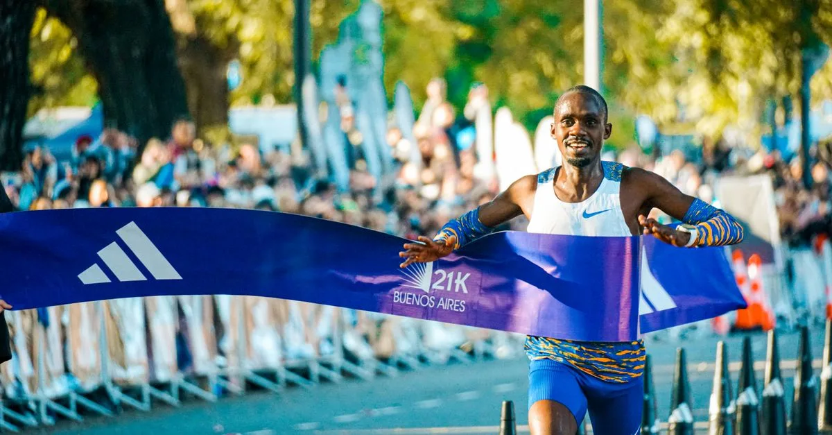 Male athlete crossing the finish line at the Buenos Aires marathon in a lively outdoor event.