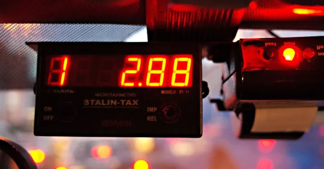Close-up of an illuminated taxi meter reading '2.88' during nighttime inside a vehicle.