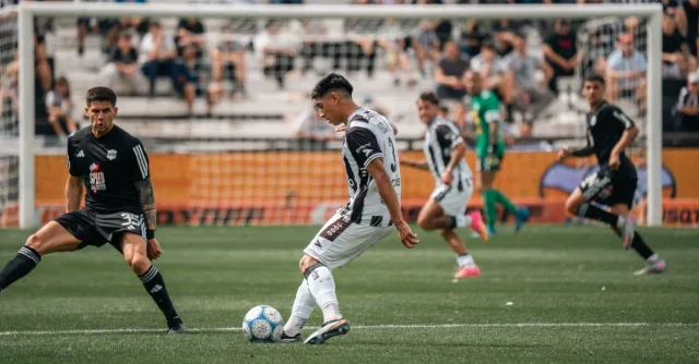 Intense moment during a soccer match with players in motion on the field.