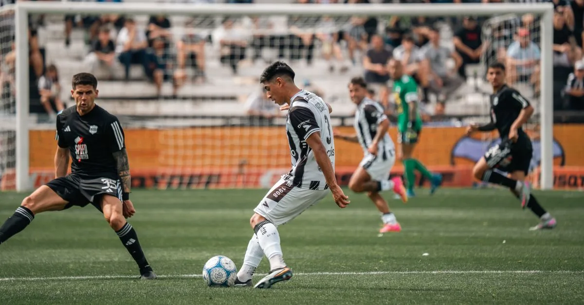 Intense moment during a soccer match with players in motion on the field.