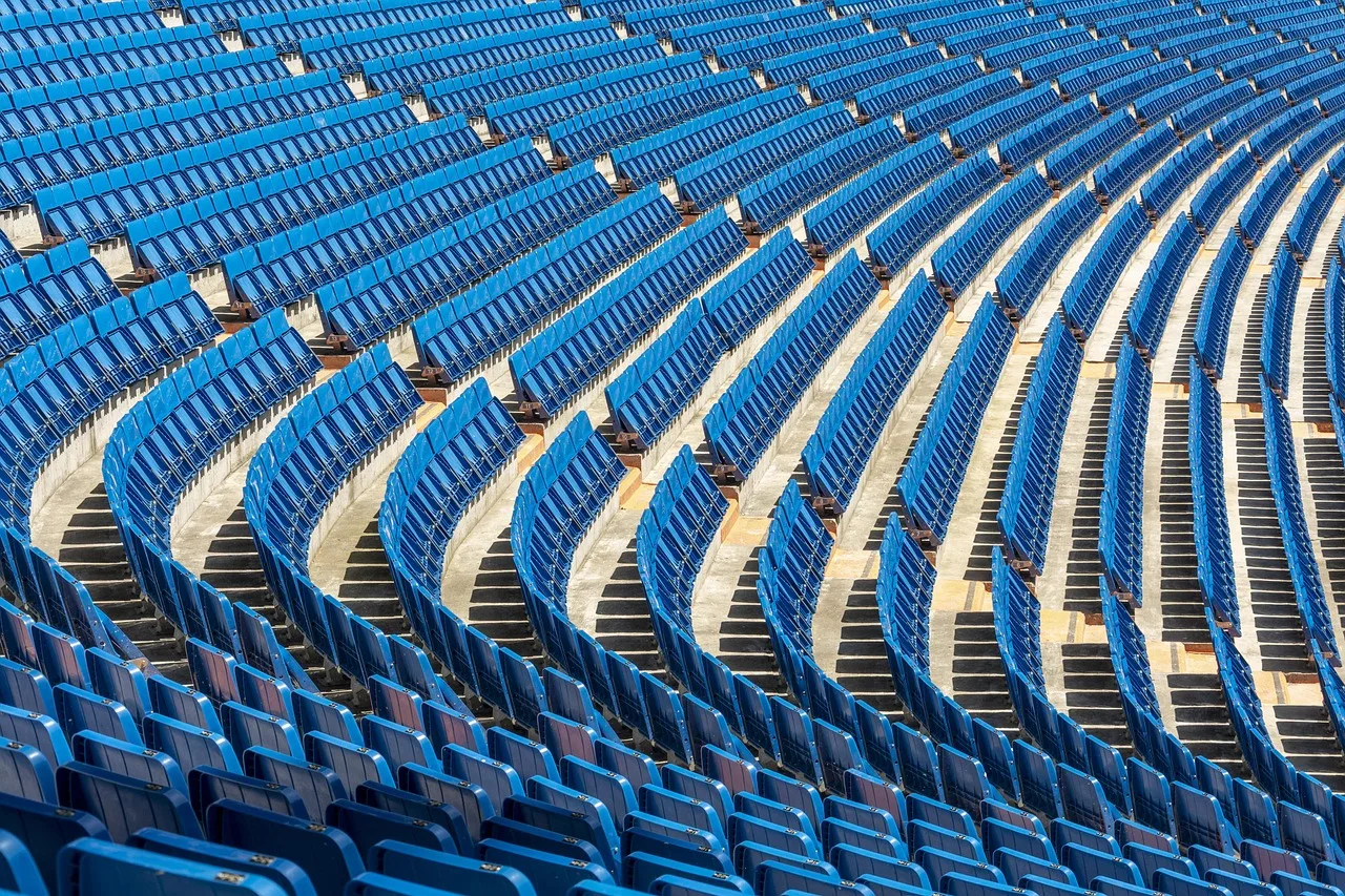 A wide view of a professional football stadium under floodlights at night.