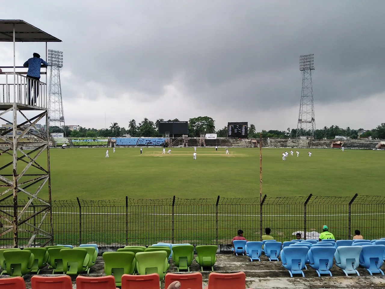 A wide shot of a professional cricket stadium under clear skies.