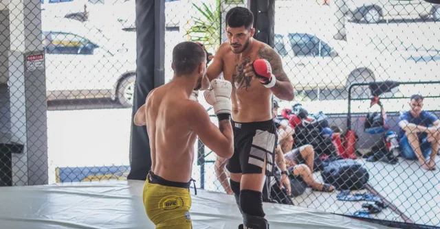 Two boxers engage in a sparring match, showcasing strength and rivalry in the ring.