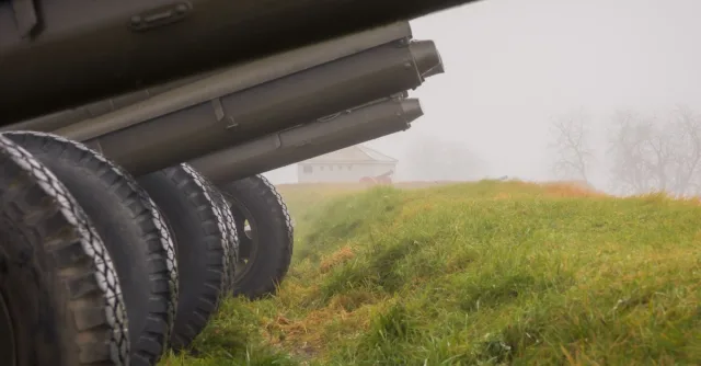 Rows of historic cannons in a foggy autumn field, embodying a sense of history and misty stillness.