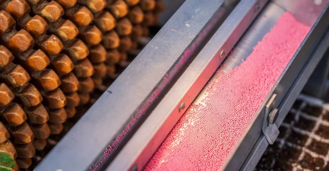 Close-up of industrial machinery with pink ball bearings and metal equipment.