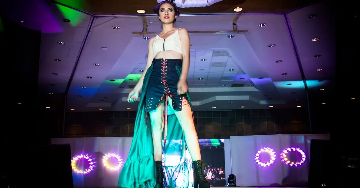 Fashion model strutting on a runway during a glamorous evening event with vibrant lights in Morelia, Mexico.
