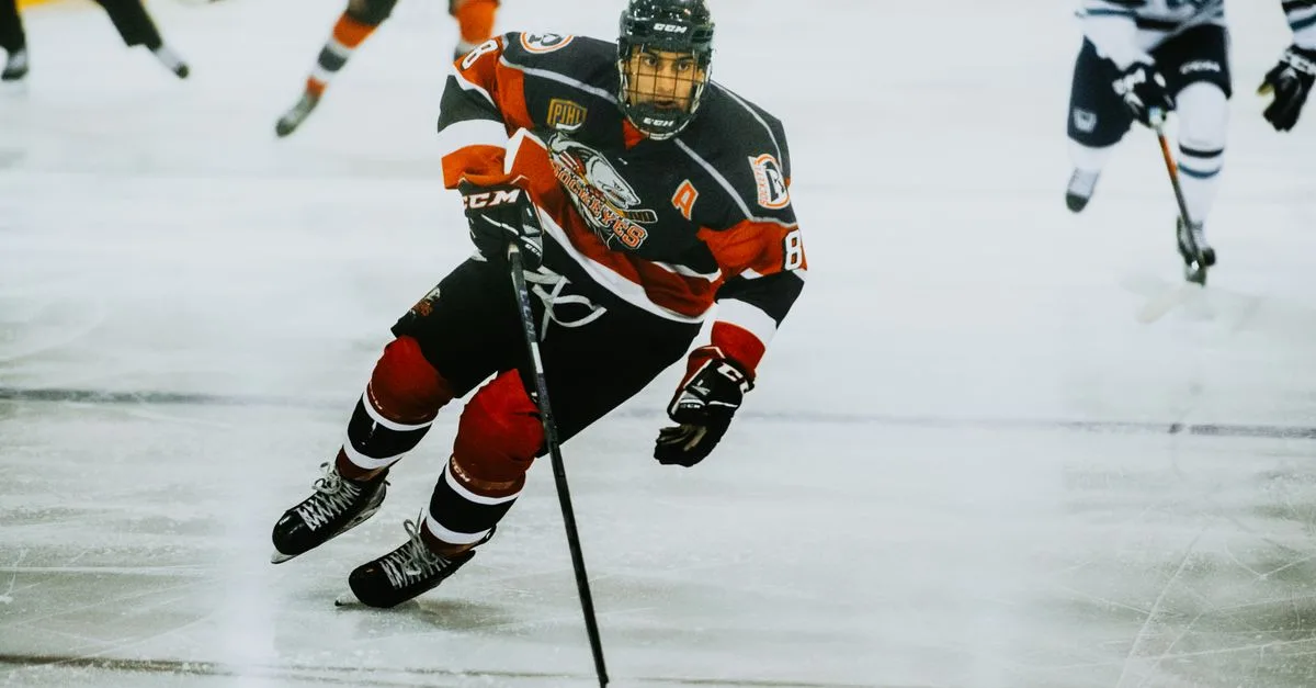 Dynamic action shot of a hockey player skating on an ice rink during a game.