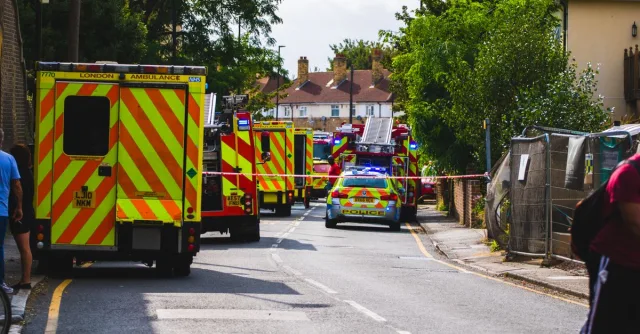 Emergency vehicles respond to an incident on a residential street, road closed.