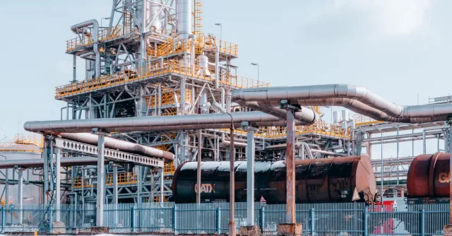 Oil refinery facility with tanker wagons in Trzebinia, Lesser Poland Voivodeship under a clear sky.