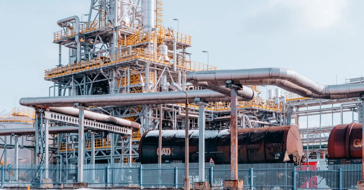 Oil refinery facility with tanker wagons in Trzebinia, Lesser Poland Voivodeship under a clear sky.