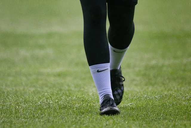 An empty professional football stadium pitch during the day.