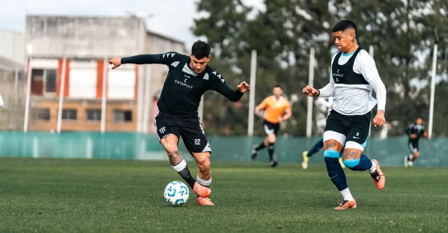 Two soccer players in mid-action during a competitive training session outdoors.