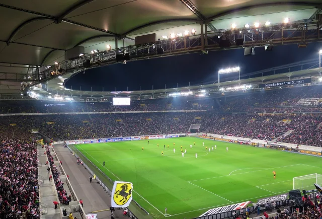 The floodlights of a football stadium illuminated at night.