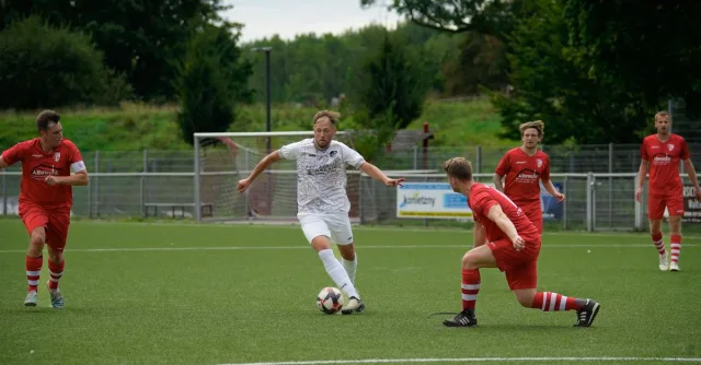 Competitive soccer players in action during a match on a green field, showcasing teamwork and athletic skill.