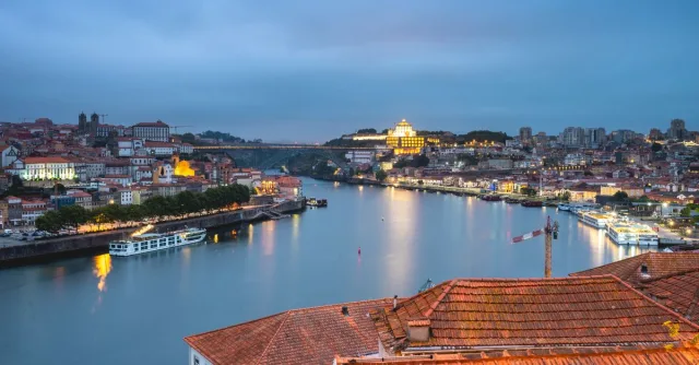 Stunning view of Porto cityscape and Douro River at twilight, highlighting Portugal's architectural beauty.