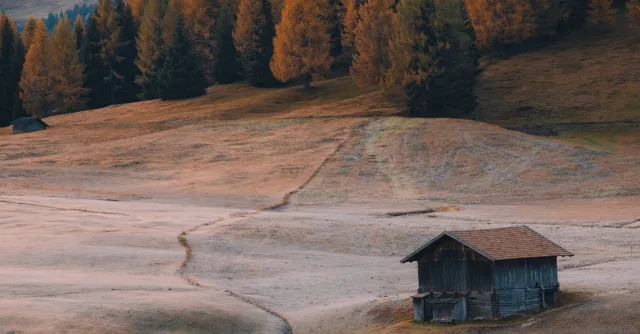 Charming rustic hut in the autumnal landscape of the Dolomites, Italy.