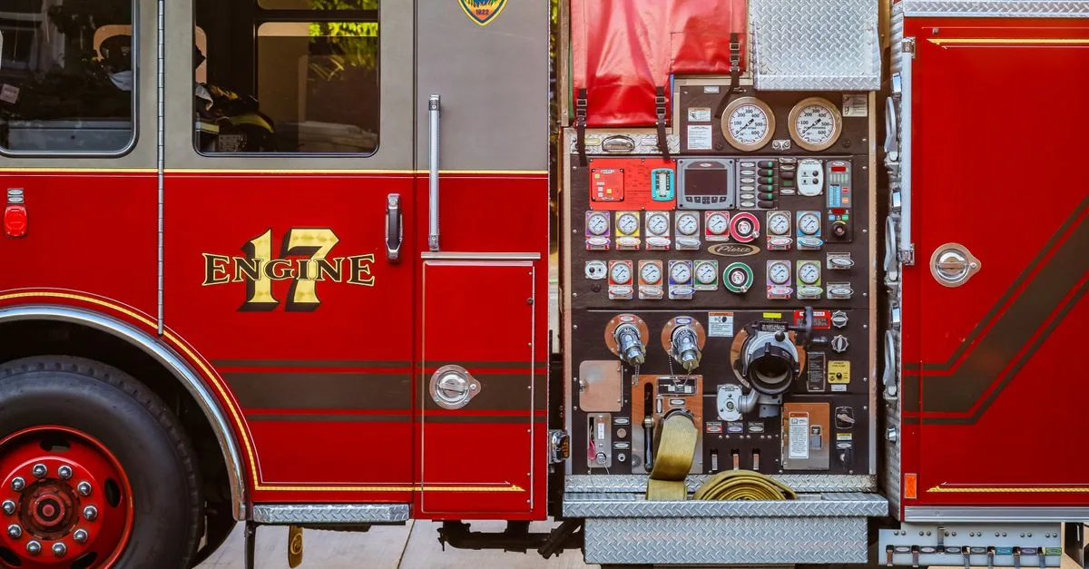 Detailed view of a fire truck's control panel and side compartment with equipment.