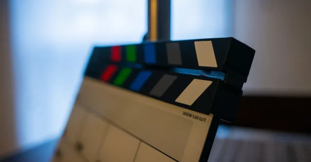 Detailed view of a film clapperboard indoors, highlighting film industry tools.