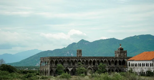 Ancient ruins with mountainous backdrop, showcasing timeless architecture amidst natural beauty.