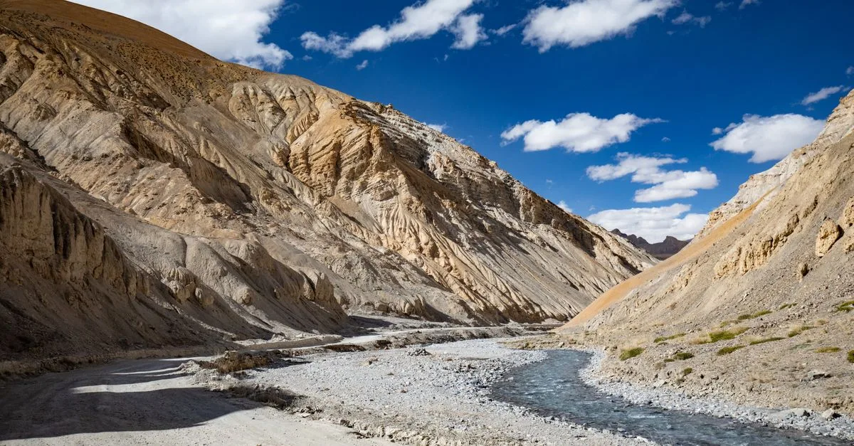Stunning landscape of a flowing river amidst rugged mountains in Ladakh, India.