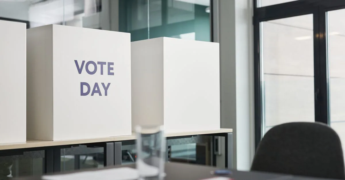 A modern office with voting booths labeled 'Vote Day' indicating election activity.