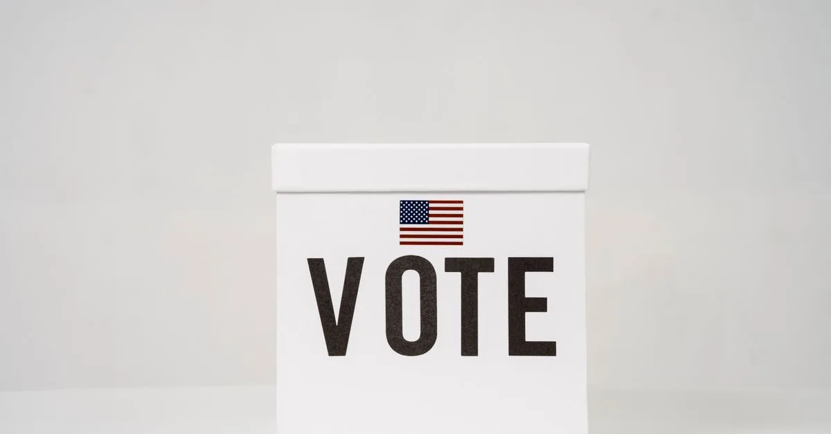 A minimalist ballot box with 'Vote' and an American flag, symbolizing elections.