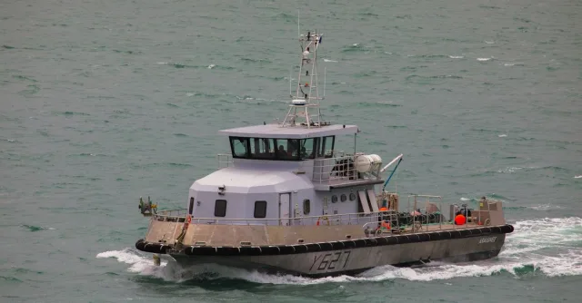 A patrol boat cruises through the choppy waters of Normandy, France, showcasing maritime security.