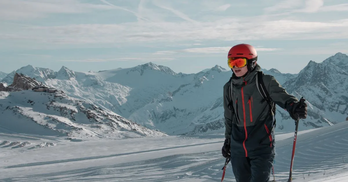A skier enjoying the snowy slopes with alpine mountain views under clear skies.