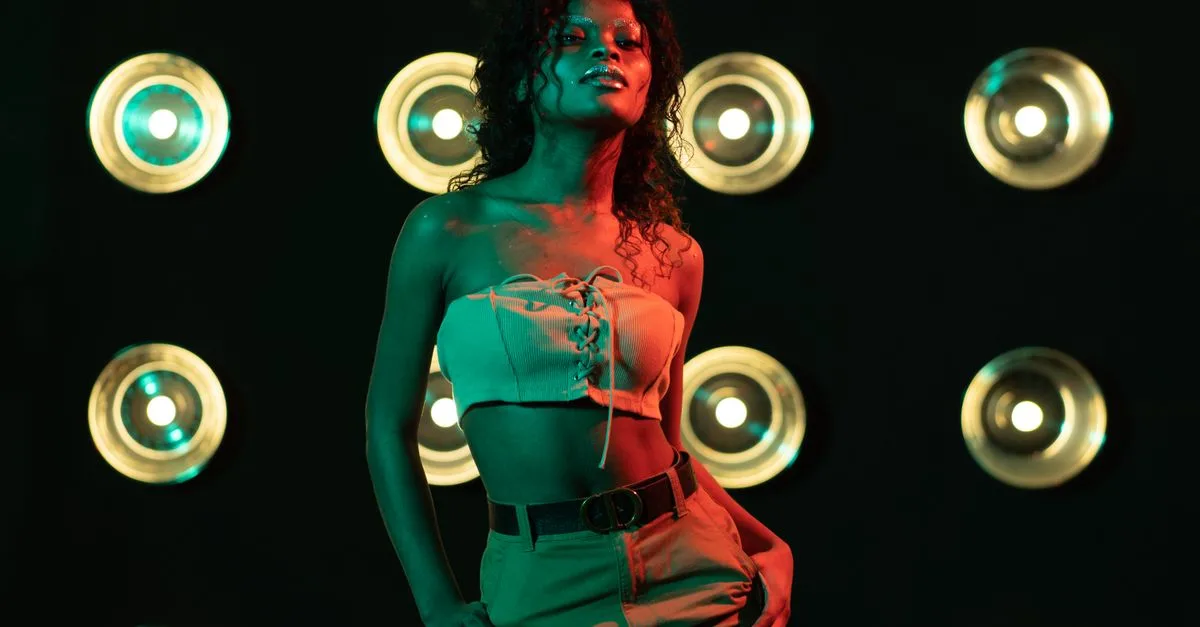 Stunning image of a stylish African woman posing confidently in a studio, highlighted by artistic lighting.