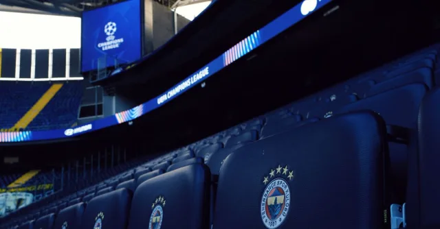 Rows of empty seats in a stadium with UEFA Champions League branding.