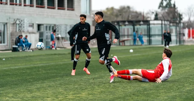 Athletes compete in an intense soccer match, highlighting sports action and agility.