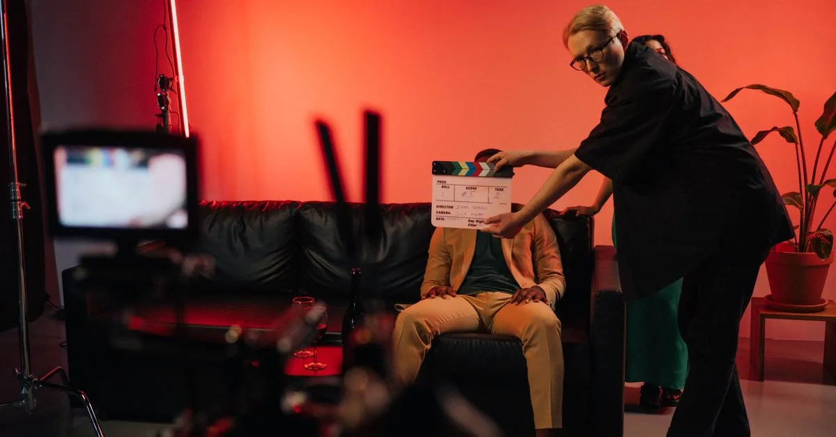 Film production team setting up a scene on an indoor set with dramatic lighting.