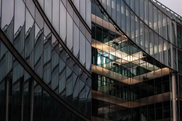 A modern glass office building exterior representing a corporate agency.