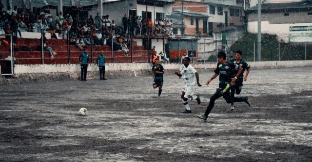Exciting soccer game in Neira, Colombia, capturing athletes in action during a rainy match.