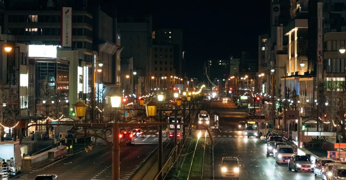 A bustling night scene of Toyohashi's illuminated city street, capturing vibrant urban life.