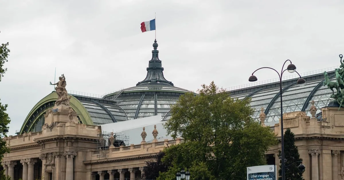 View of the Grand Palais in Paris featuring the iconic glass dome and French flag.
