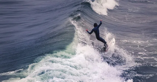 Dynamic shot of a surfer expertly riding waves at Pismo Beach, showcasing skill and thrill.