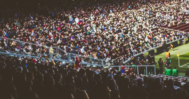 A crowded soccer stadium packed with enthusiastic fans during a match.
