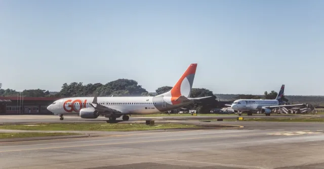 Airliners taxiing on a sunny day at an airport, ready for takeoff.