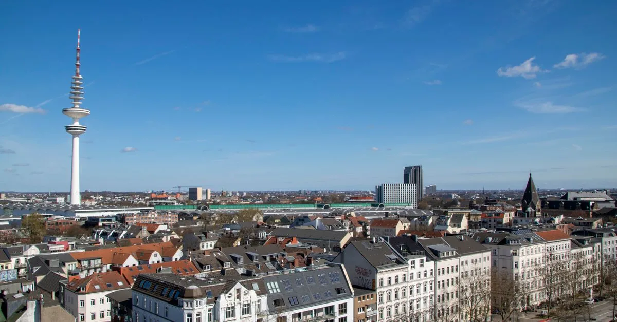 A stunning aerial view of Hamburg's skyline featuring the iconic Fernsehturm under a clear blue sky.