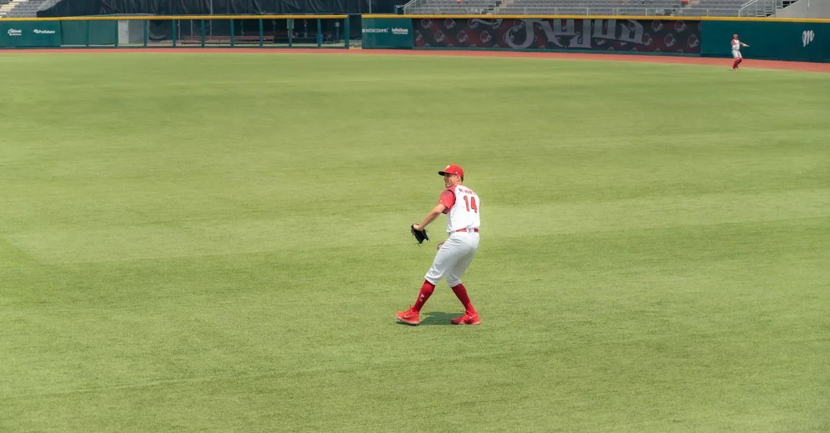 Baseball player in action on grass field during a daytime game at stadium.