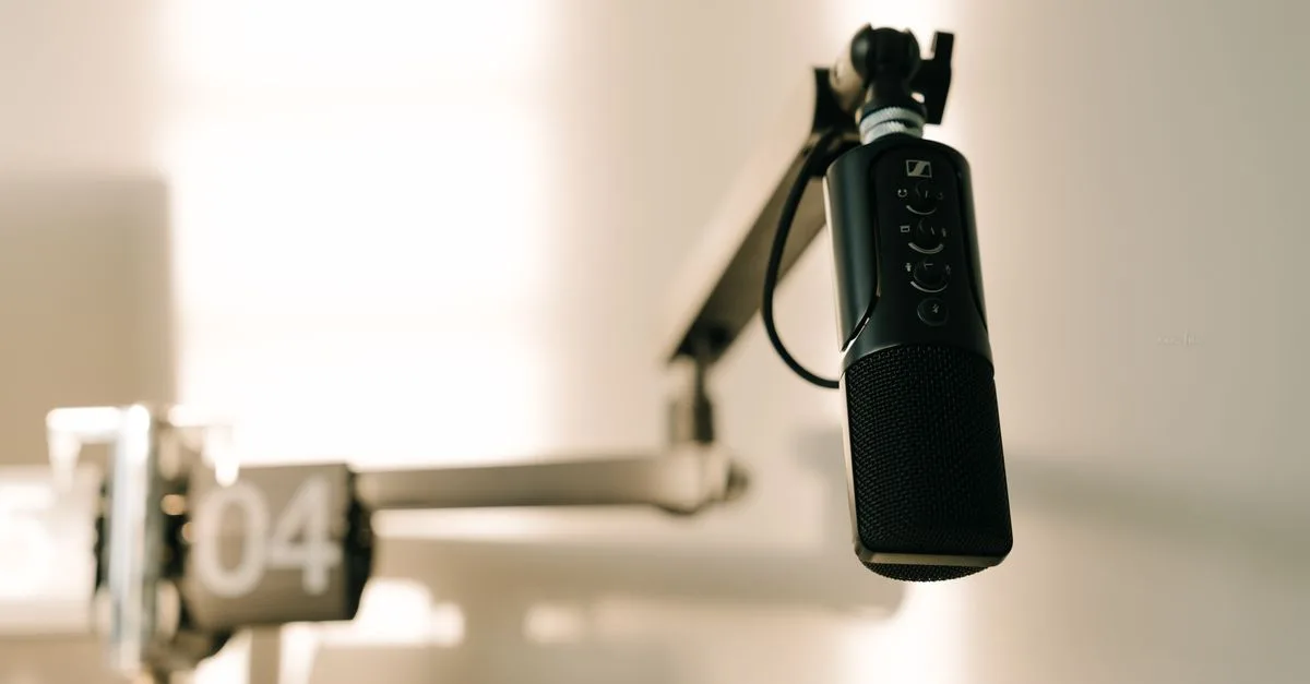 A sleek professional microphone on a boom arm in a minimalist studio.