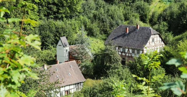 Explore traditional Fachwerk houses nestled in a lush forest landscape, showcasing rustic charm and heritage.