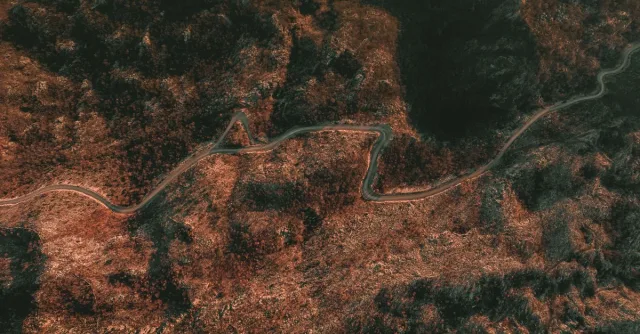 Stunning aerial view of a winding road cutting through rugged mountains in Fundina, Montenegro.