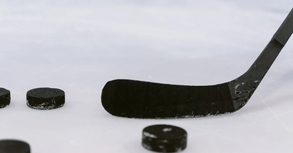Detailed view of a hockey stick and pucks on ice, perfect for sports visuals.