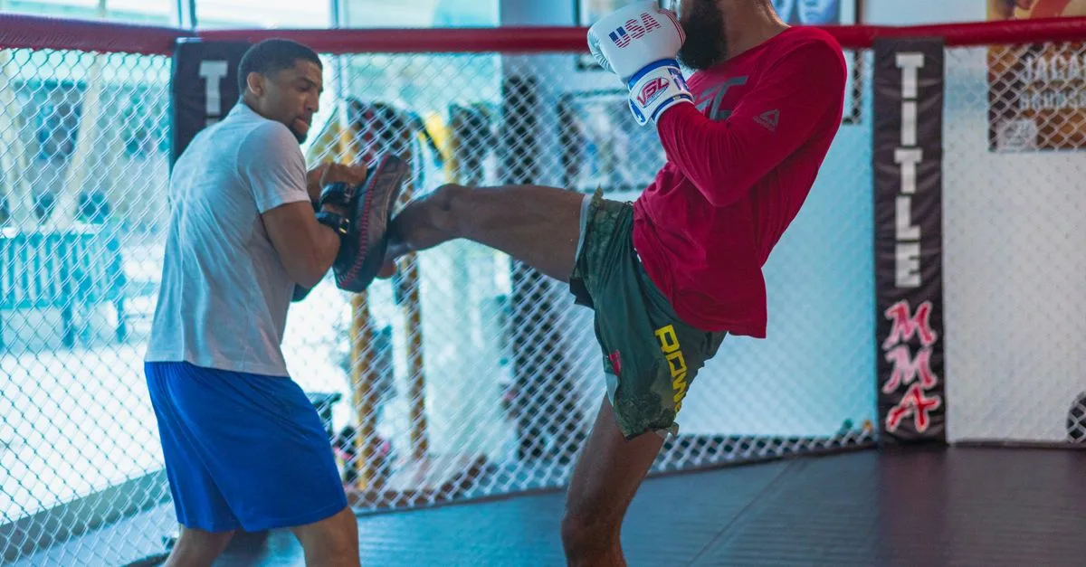 Dynamic kickboxing training session featuring two athletes in action inside a gym.