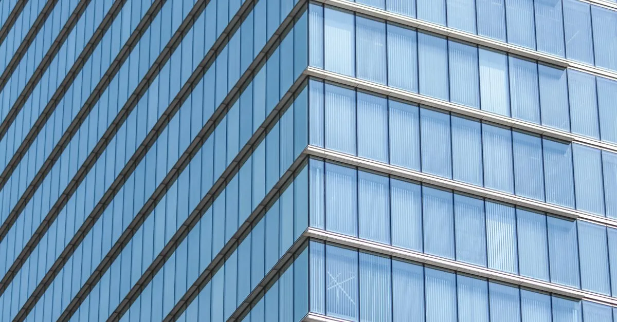 Close-up of a modern glass building facade showcasing geometric lines and reflections.