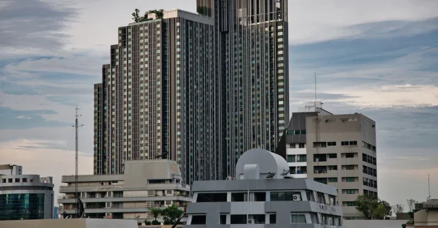 Skyline of modern high-rise buildings in Bangkok, Thailand with a moody sky.