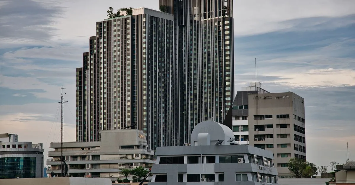 Skyline of modern high-rise buildings in Bangkok, Thailand with a moody sky.