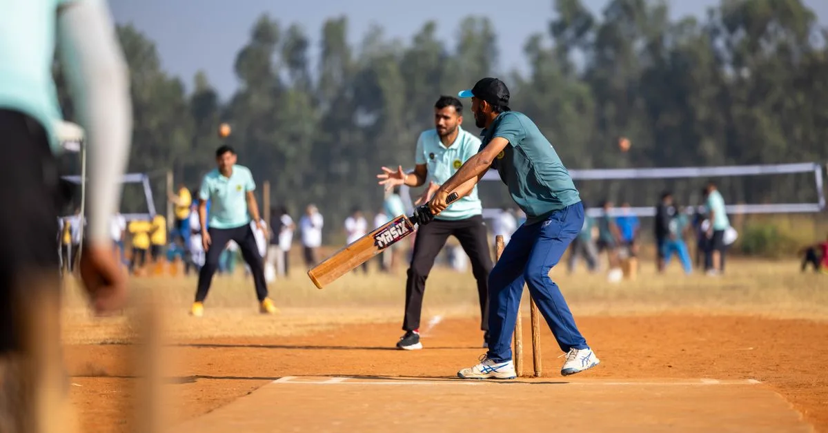 Dynamic scene of a cricket match capturing the batsman in action on an outdoor field.